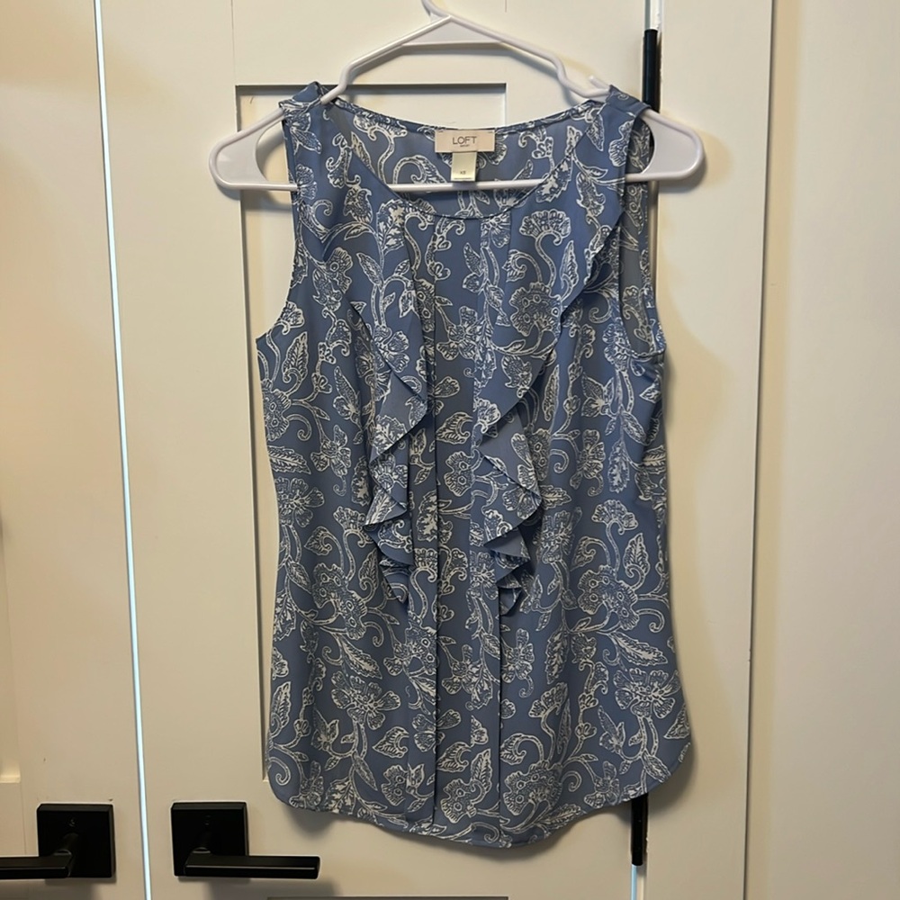 Loft, periwinkle blue blouse with white flower detail. Ruffles down the front.